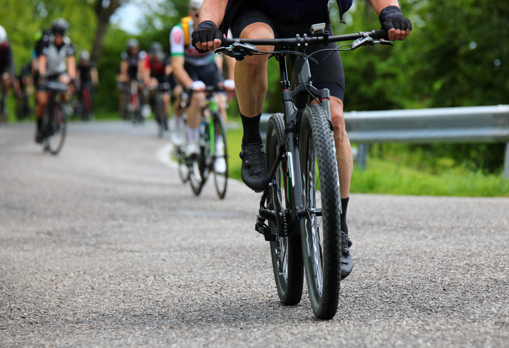 Gravel bike racing on mixed terrain with other cyclists iStock