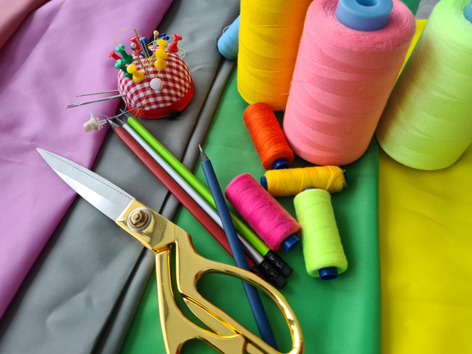 Colorful Sewing Supplies On Green Fabric iStock