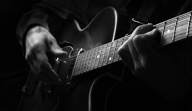 Playing an Acoustic Guitar. Guitarist hands and guitar close up. black and white iStock